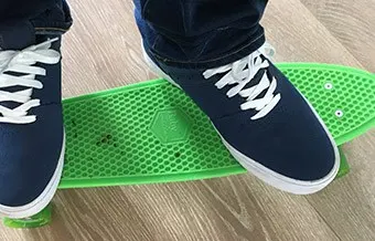 someone standing on a plastic penny board